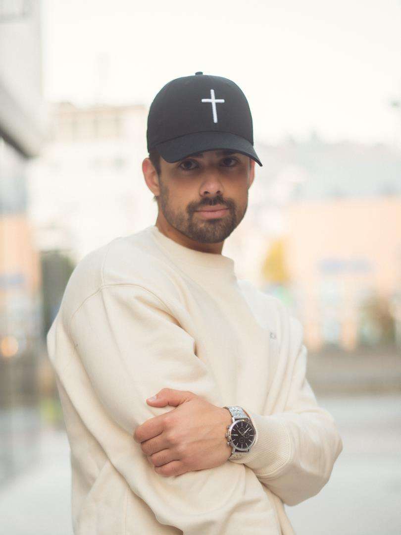 Modischer Mann mit Christenhut und Kreuz-Design, Streetstyle Look, Kleidung für Christen.