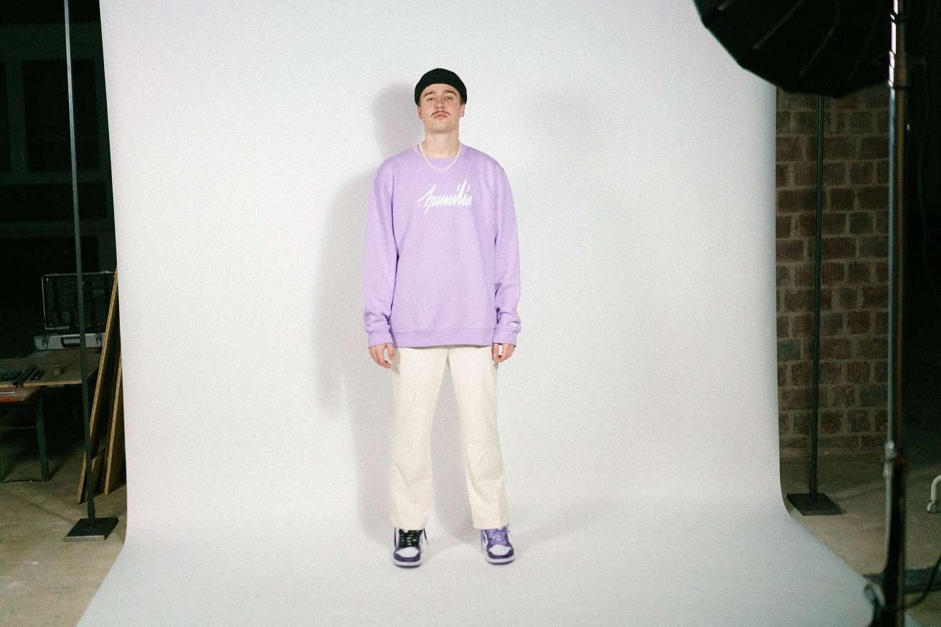 humilia essentials Sweatshirt - Lavender 6 Stylischer junger Mann in Streetwear für christliche Marken, Fotoshooting im Studio.