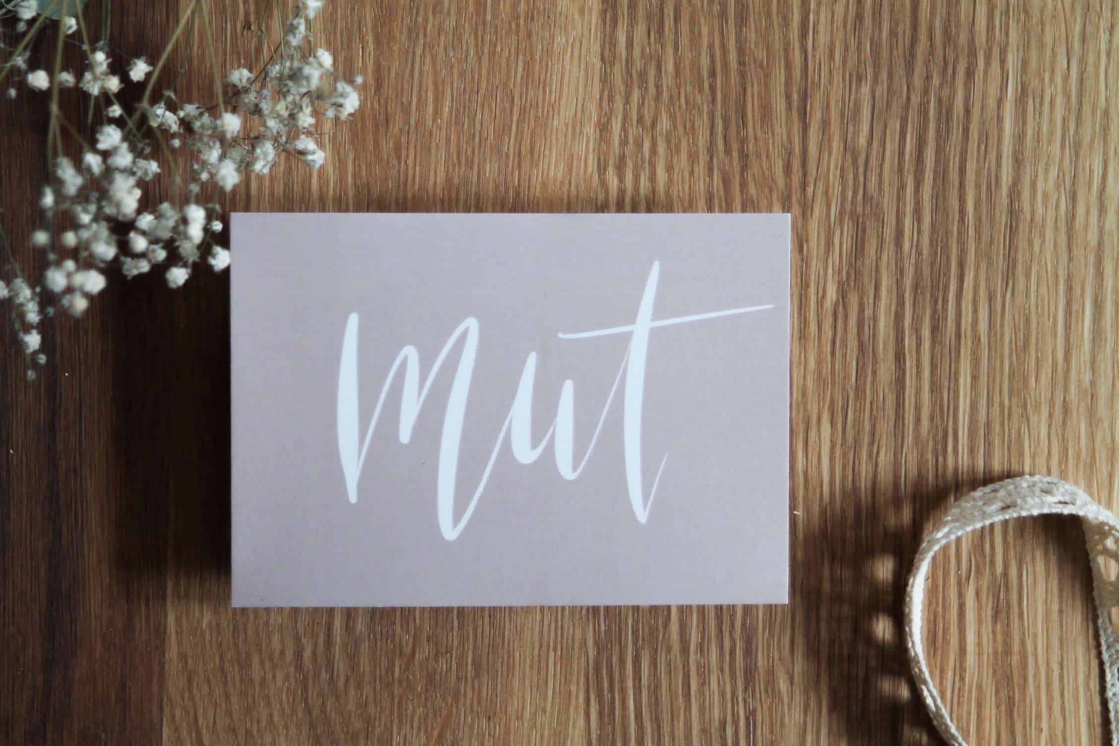 Grußkarten-Set "erMUTigung" 2 Moderner christlicher Grußkarten-Aufdruck "Mut" auf Holztisch.