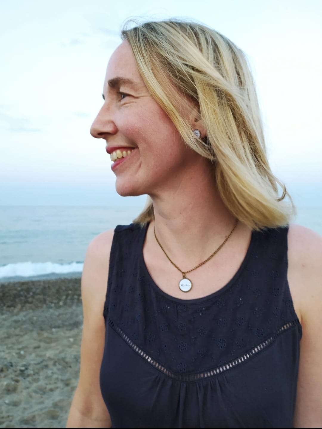 Ohrstecker Königstochter 2 Fröhliche Frau mit christlichem Schmuck am Strand, Glaube und Inspiration.