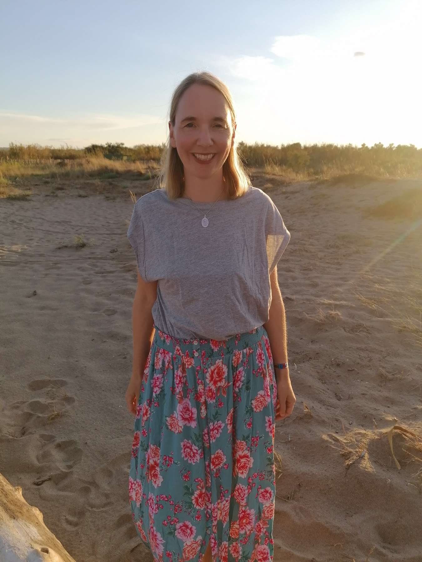 Halskette Löwe 2 Lebensfrohe Frau am Strand mit Sonnenuntergang, christliche Lifestyle, positive Ausstrahlung.