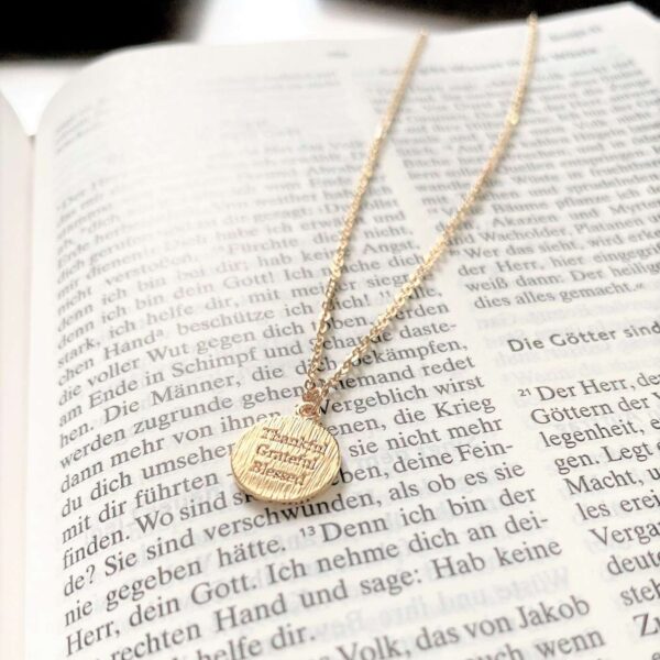 Glaubensarmband mit christlichem Spruch auf goldener Kette, religiöse Schmuckaccessoires.