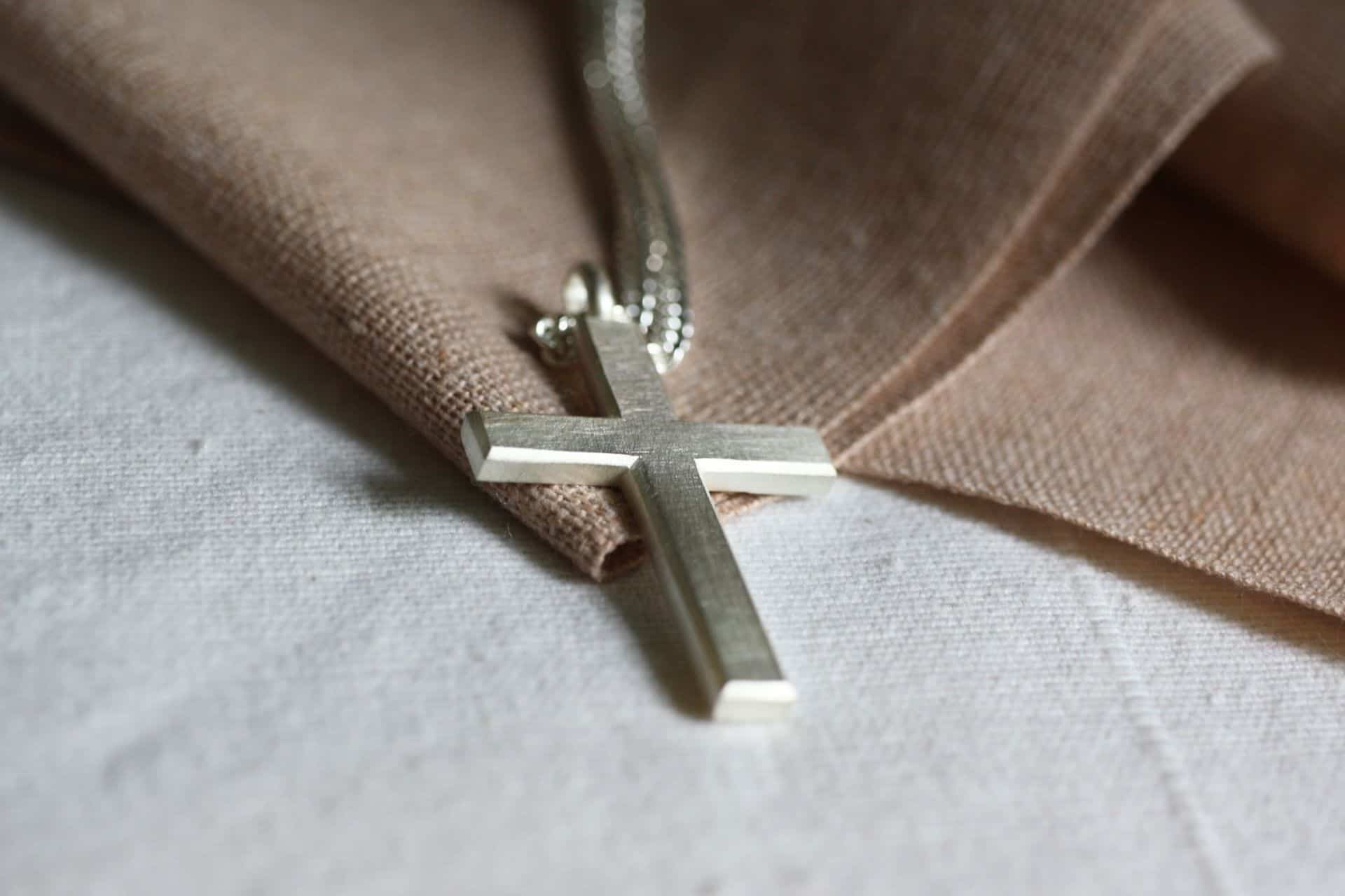 Halskette mit Kruzifix, christliches Schmuckstück, religiöser Schmuck, Glaube, Andacht.