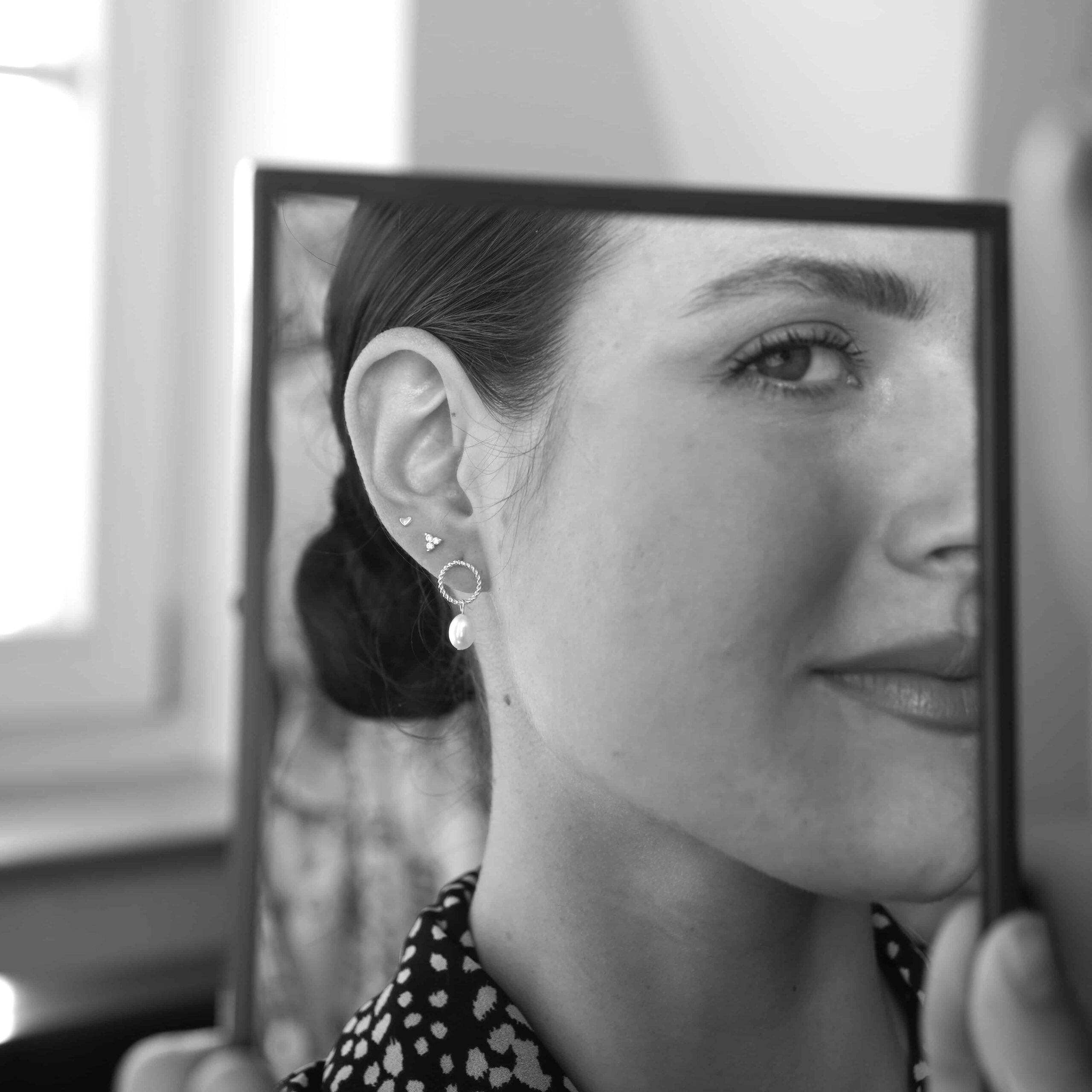 Esther | Christliche Ohrstecker – 925 Sterling Silber vergoldet – Süßwasserperle 5 Stilvolle Frau schaut in den Spiegel, Schmuck und Make-up, Selfie, urbaner Look.