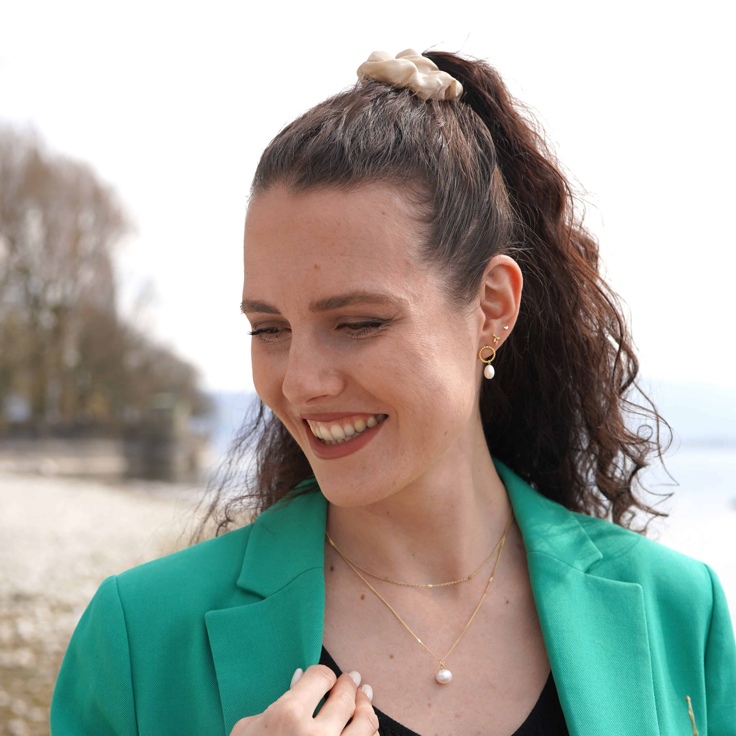 Maloa | Christliche Kette – 925 Sterling Silber vergoldet – Süßwasserperle – 45cm lang 2 Glückliche Frau mit christlicher Mode, Schmuck und grünem Blazer am Strand.