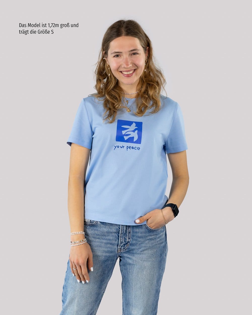 Begeisterte junge Frau trägt christliches T-Shirt mit Friedenssymbol, Mode & Glaube.