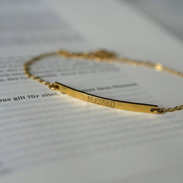 Goldene Halskette mit „Blessed“-Schriftzug, christliches Schmuckstück, spiritueller Schmuck.