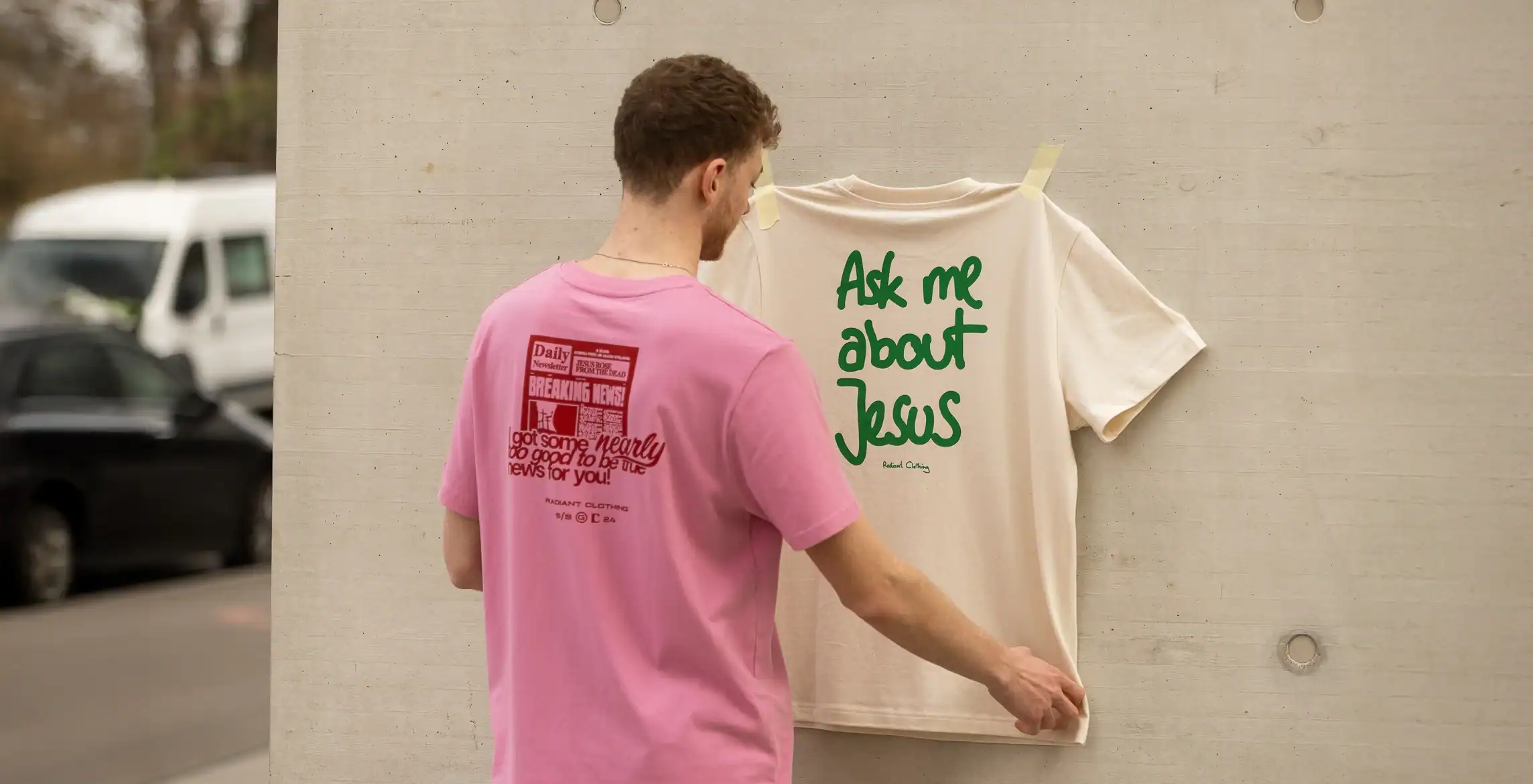 Modischer junger Mann betrachtet christliches T-Shirt mit Bibelvers, evangelischer Street Style.