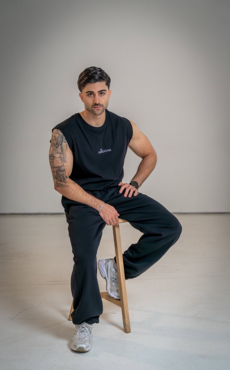 Essential Tanktop - "Philippus" 15 Moderner Mann trägt schwarze Sportkleidung mit christlichem Logo.