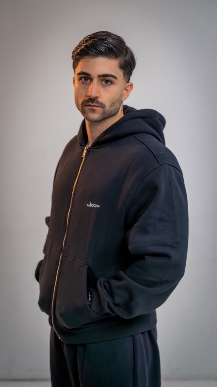 Essential Zipper - "Thomas" 14 Moderner Mann in schwarzer Hoodie, Mode für junge Menschen, lässiger Stil, stilvolle Kleidung.