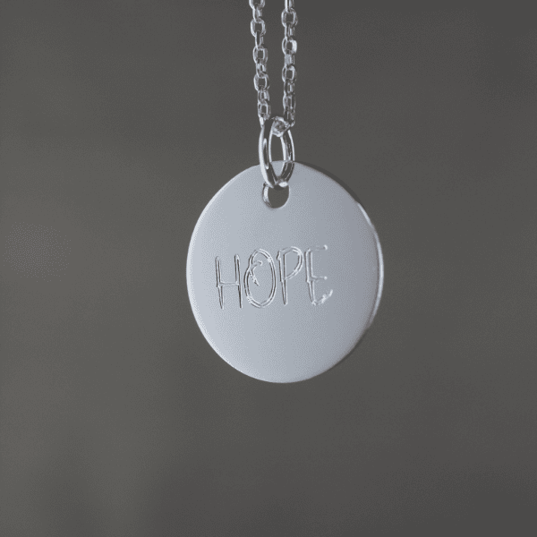 Hoffnungsanhänger mit christlichem Design, symbolisiert Glauben und Hoffnung in der Kirche.