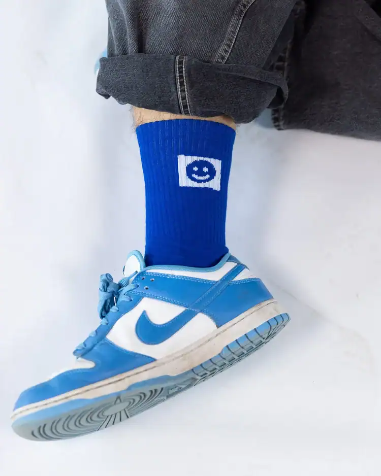 Joy Socken 8 Gebogener Hemdärmel mit Blue Nike Sneaker und Christlicher Socke mit Smileygame.