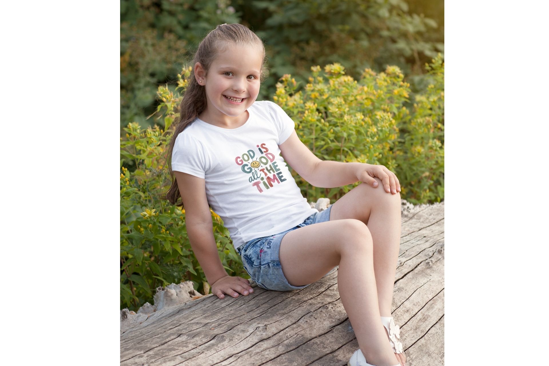 God is good all the time Gute Laune T-Shirt aus Bio Baumwolle 10 Glaube, Freude und Natur: Mädchen sitzt auf Baumstamm im Grünen, christliche Botschaft.