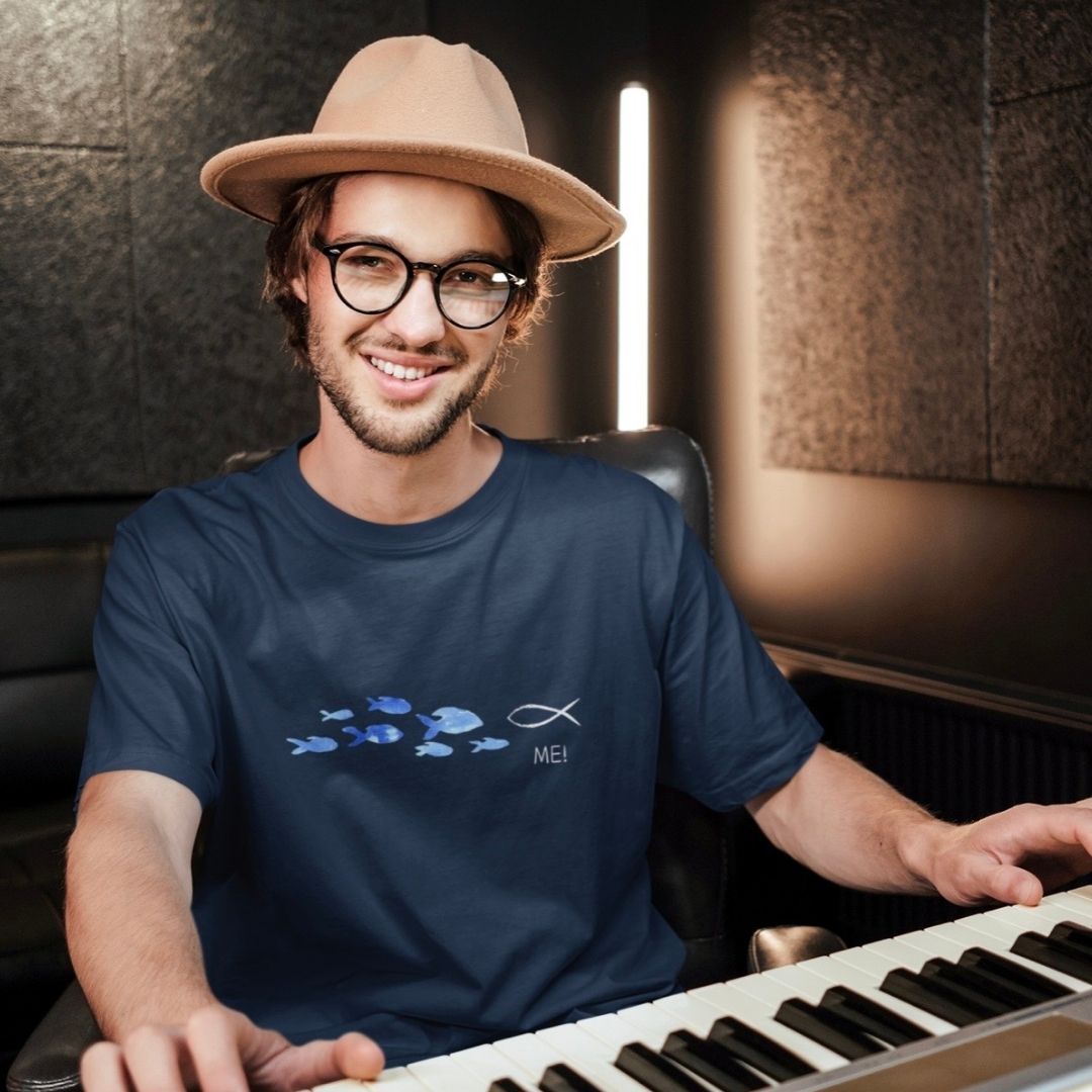 ME! gegen den Strom - aussagekräftiges T-Shirt Bio Baumwolle 13 Der junge Mann spielt Klavier, trägt Hut und Brille, in moderner christlicher Atmosphäre.
