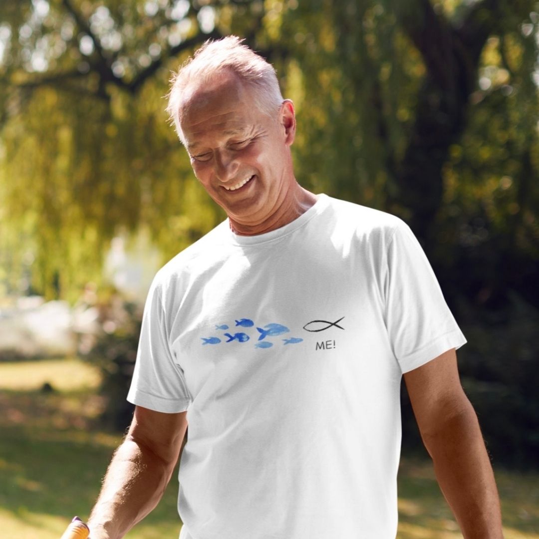 ME! gegen den Strom - aussagekräftiges T-Shirt Bio Baumwolle 11 Ein älterer Mann trägt ein weißes T-Shirt mit Fisch-Design und christlichem Text, im Park.
