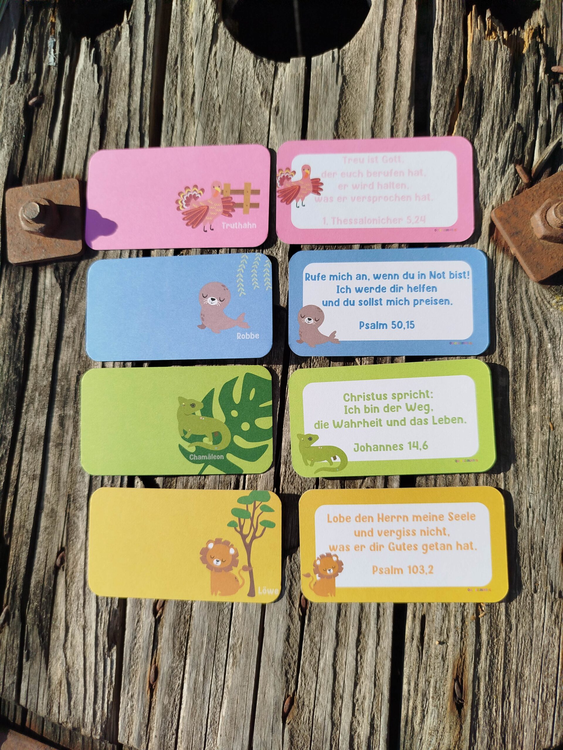 Minikarten mit Bibelversen 16 Bunte Bibelvers-Karten mit Tiermotiven auf Holzuntergrund.
