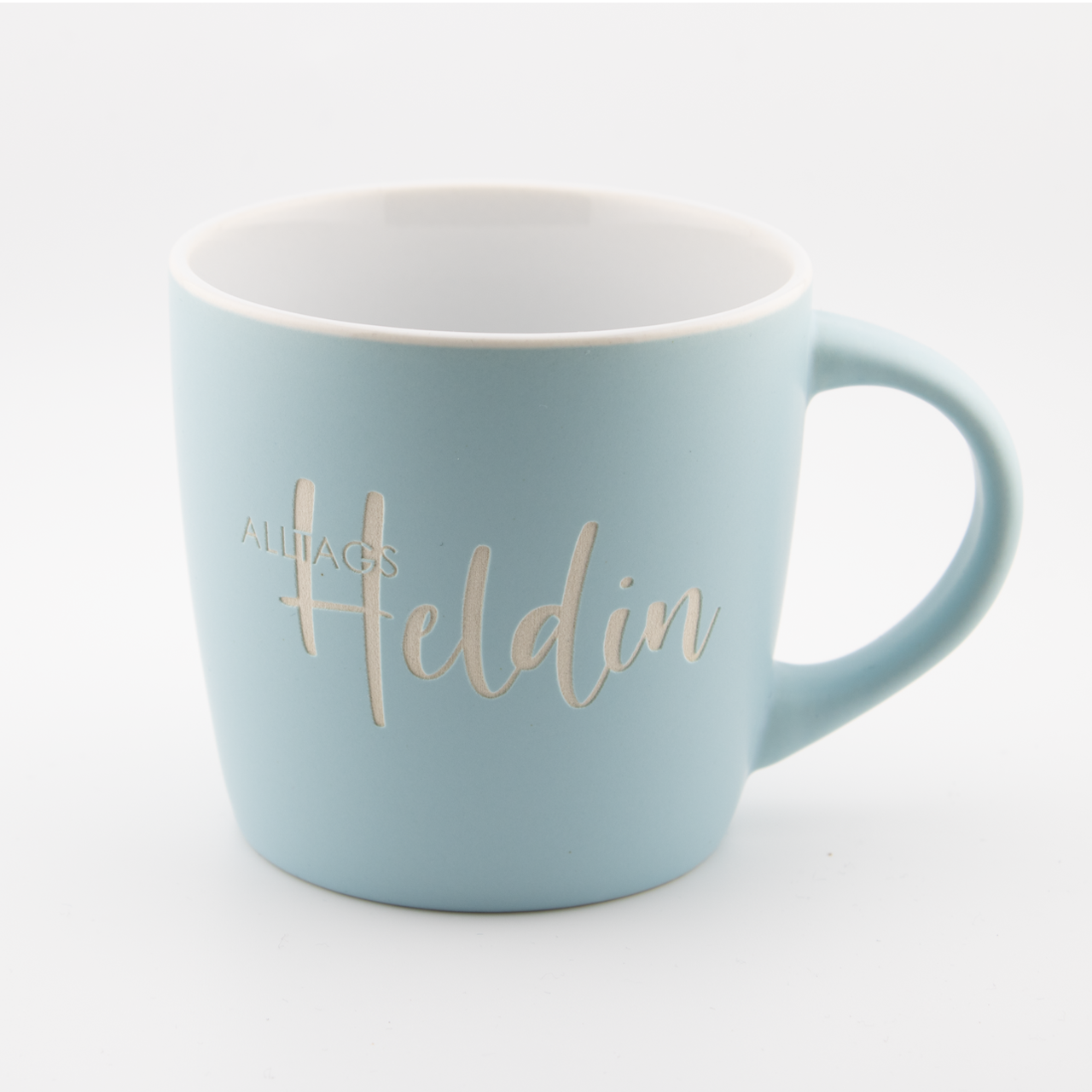 Alltagsheldin | Tasse 1 Hellblaue Tasse mit goldener Beschriftung 'Alltags Heldin' auf weißem Hintergrund.