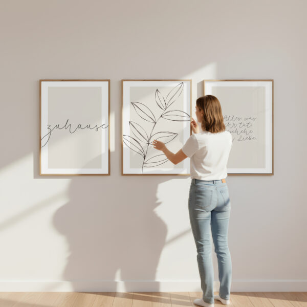 Frau betrachtet drei moderne Kunstwerke mit Pflanzenmotiven an der Wand.