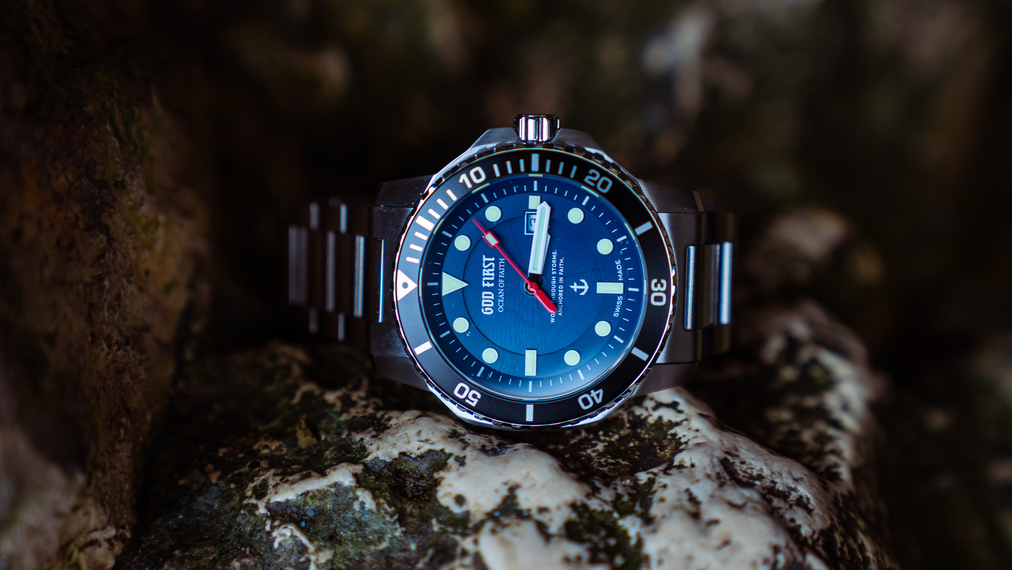 OCEAN OF FAITH - Schweizer Uhren inspiriert vom Glauben - Blau Edelstahl 3 Bunter Taucheruhr mit blauer Lünette auf moosbedecktem Stein.
